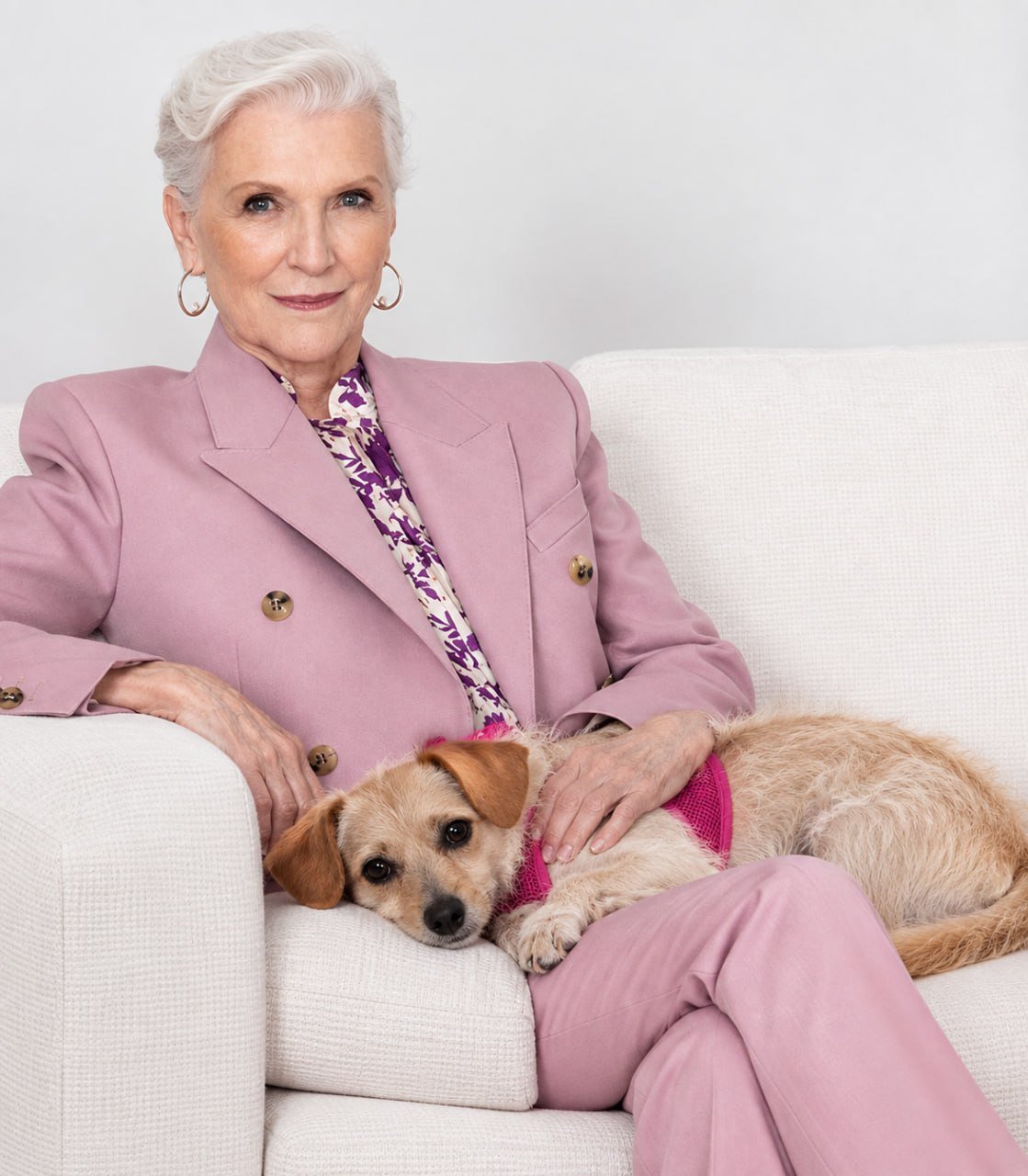 Cali resting on a cream sofa beside Maye Musk